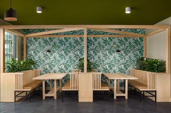A room with a green wallpaper and wooden furniture.